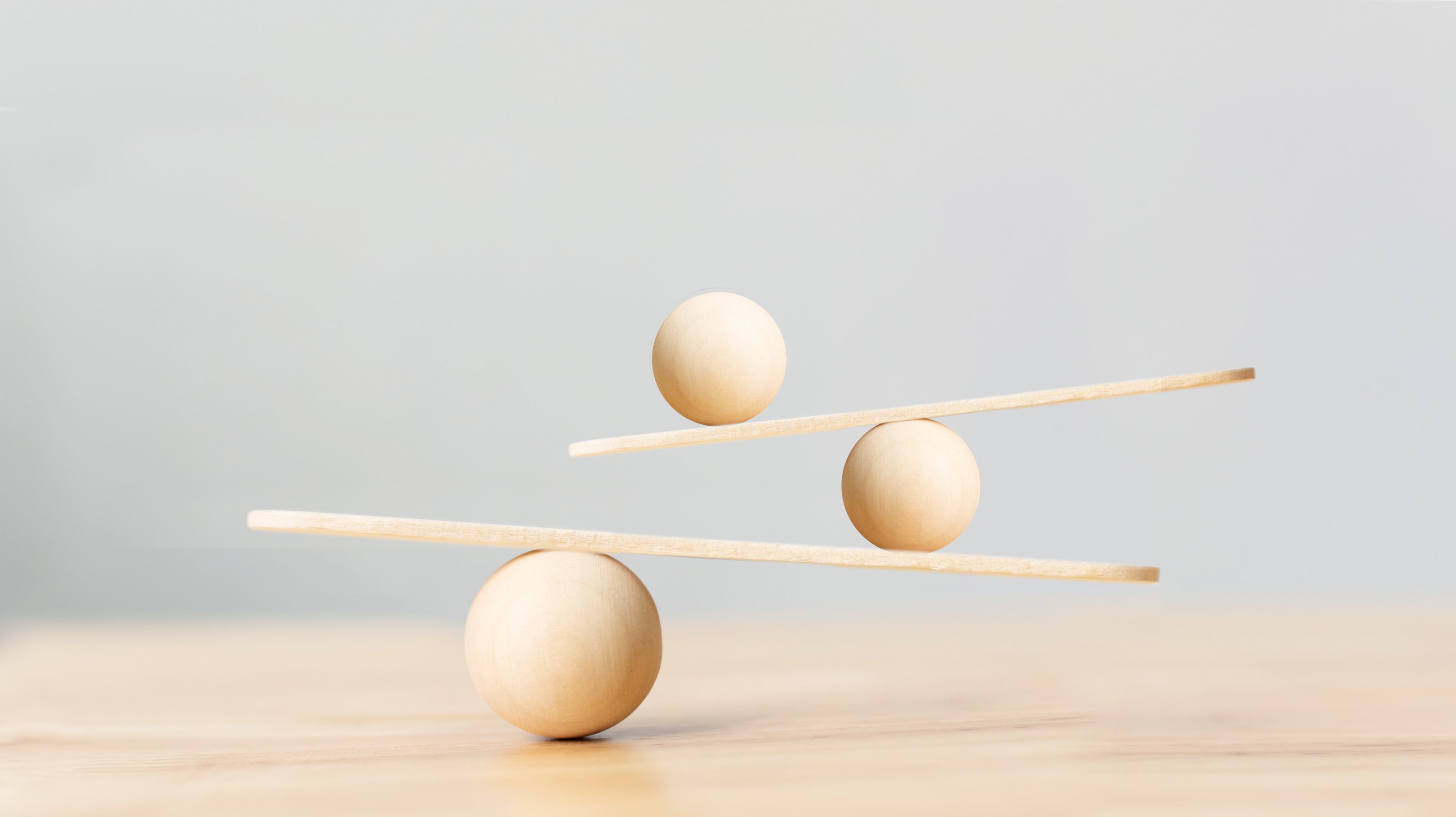 Wooden scale balancing on seesaw. Concept of harmony and balance